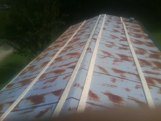 Rusted metal roof panels with new wood purlins before replacement — Storm Damage Roof Repair in Tracy City by Roofing Brothers