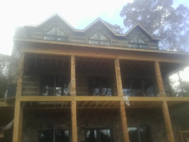 Dormers and porch framing on a large log home under construction — Roof Coating work by our crew in Tracy City