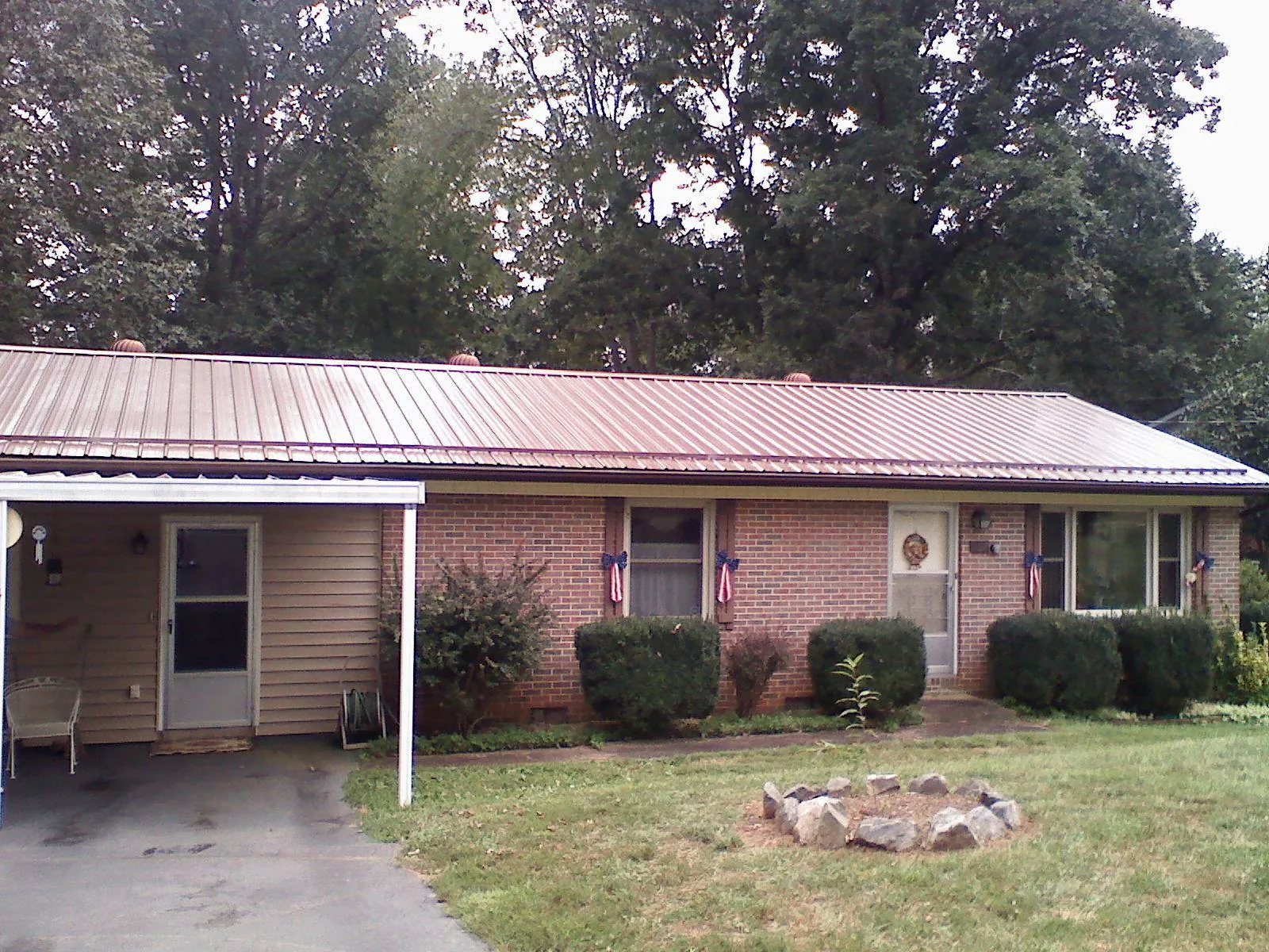 Bronze metal roof and carport on a brick ranch home — Roof Repair work by our crew in Tracy City